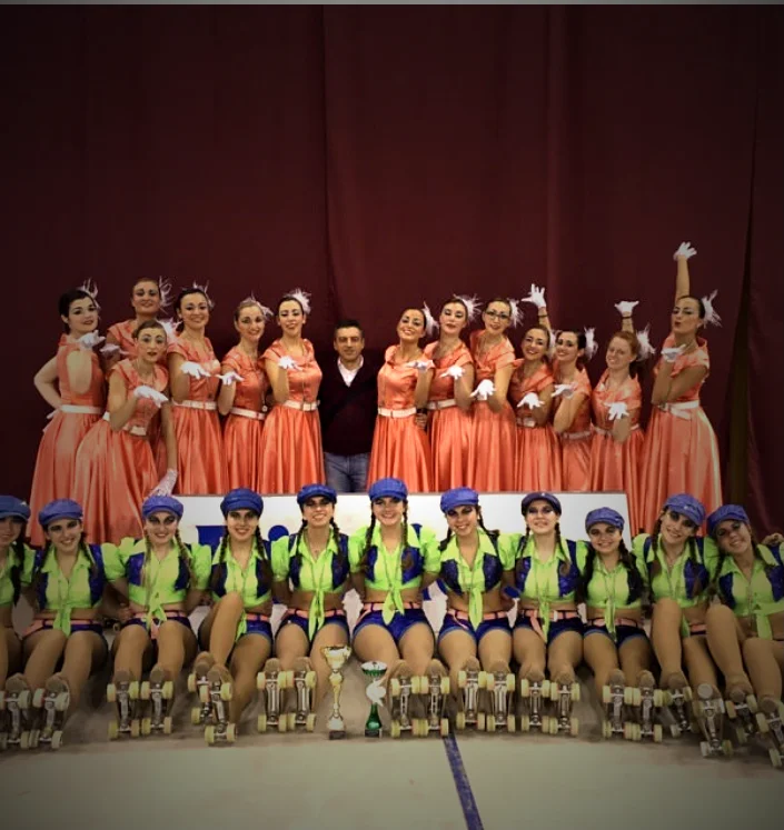 Gruppo di pattinatori in costume con trofei